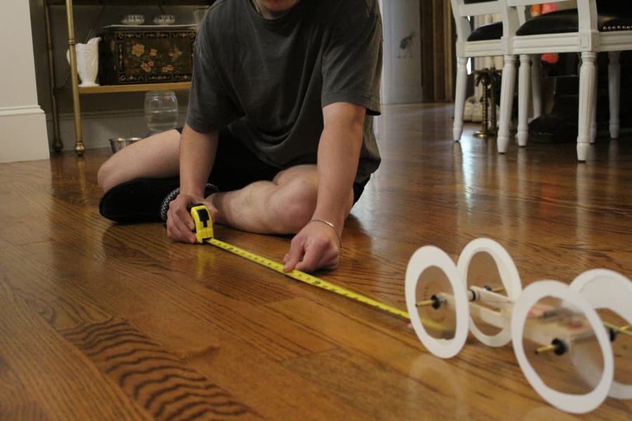 Student measuring how far the mousetrap car traveled